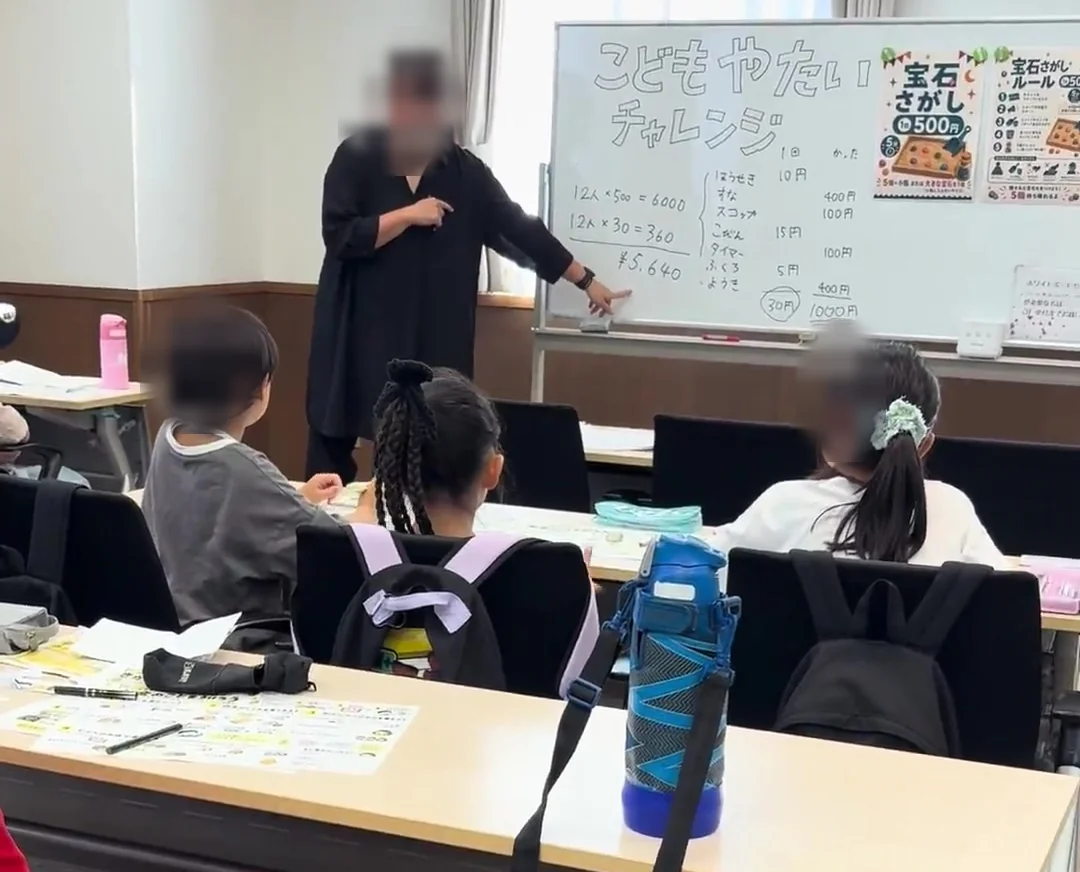 ホワイトボードで商品の費用や売上について説明する様子。人物の顔が判別できる部分のみ加工済み